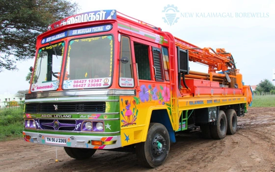 A truck with an appealing pattern on the side, bright paint, and borewell equipment on the back