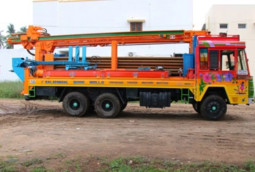 A truck with a crane attached was parked in ground, ready for 6.5 borewell drilling services.